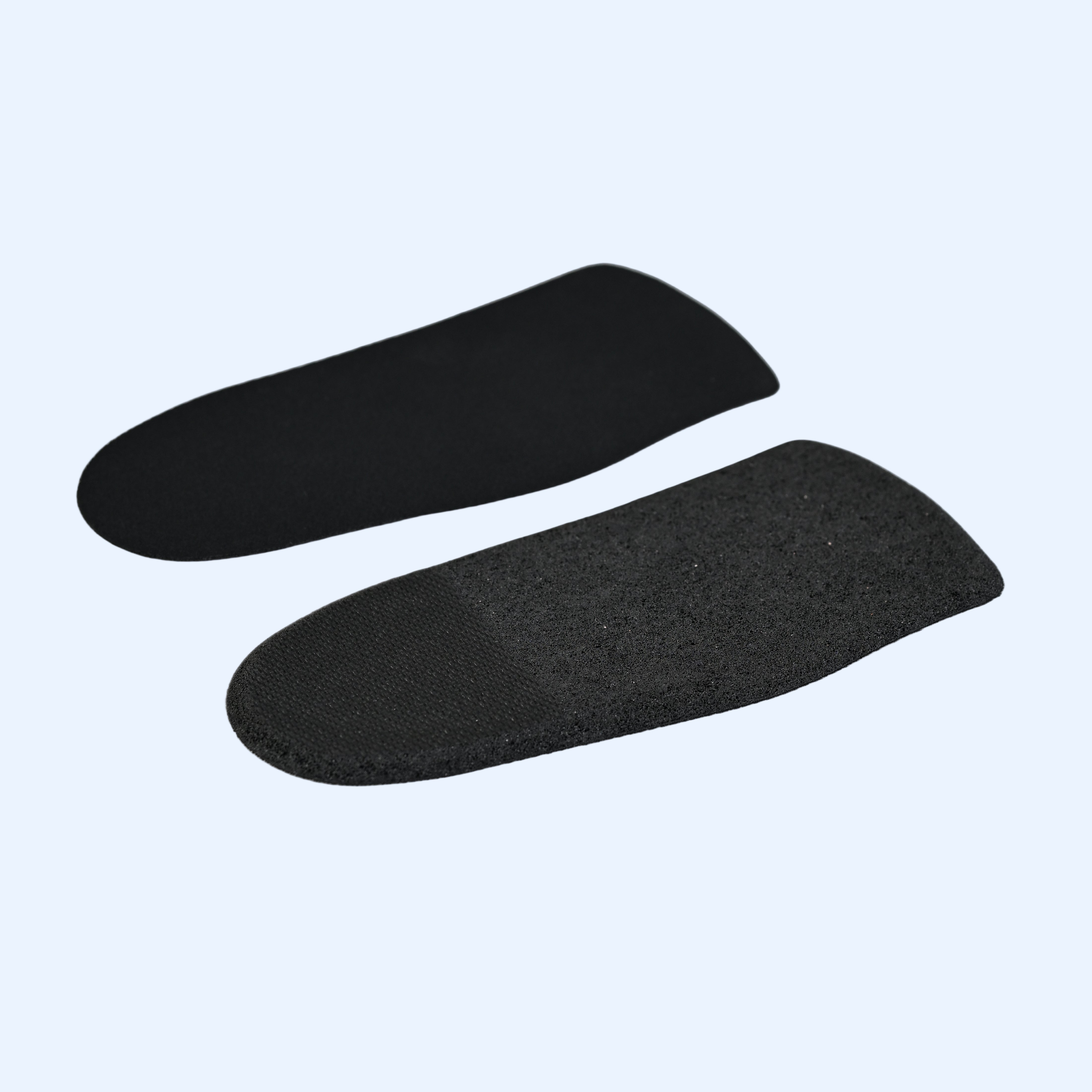 Two black shoe inserts on a white background